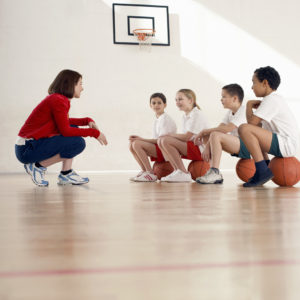 Entrenadora con equipo de baloncesto infantil mixto